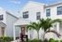 Chic modern villa featuring stylish architecture, lush tropical landscaping, and inviting entryway.