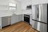 Modern kitchen with sleek stainless steel appliances, elegant white cabinetry, and warm wooden flooring.