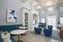 Elegant and spacious living room with modern decor, featuring blue seating, stylish artwork, and ample natural light.
