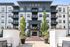 Elegant five-story apartment building 'Luxe' with modern black and white design, charming balconies, lush landscaping, and inviting entryway.