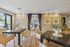 Elegant dining area with a modern design featuring sleek chairs and a stylish wooden table, adorned with greenery accents and natural stone wall decor, offering a sophisticated ambiance.