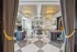 Elegant luxury apartment lobby with opulent chandeliers, sophisticated decor, and spacious marble flooring, offering a warm and inviting ambiance.