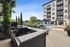 Elegant apartment community with a luxurious outdoor pool area, featuring comfy lounge chairs, umbrellas, and a state-of-the-art granite top grill station surrounded by lush greenery.