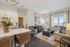 Elegant apartment interior featuring an open-concept layout with a cozy living room, modern kitchen island, and stylish decor, bathed in natural light through large windows.