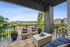 Charming balcony overlooking lush greenery featuring stylish seating and modern decor, perfect for relaxation and enjoying urban views.