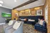 Chic entertainment room with plush velvet seating, stylish brick walls, and modern art decor. Perfect for relaxation and social gatherings.