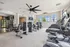 Sophisticated fitness center with modern exercise equipment and spacious layout, framed by large bright windows.