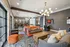 Elegant communal lounge with vibrant orange sofas, cozy seating, and modern lighting, featuring a chic arcade area and stylish decor.