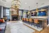 Luxurious living area with elegant lighting, cozy fireplace, modern bar seating, and stylish wooden flooring.