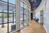 Elegant corridor with large arched windows revealing a poolside view, complemented by luxurious chandeliers and artistic wall murals.