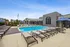Luxurious outdoor pool area with stylish sun loungers and vibrant umbrellas, perfect for relaxation on a sunny day.
