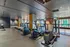 Modern fitness center equipped with state-of-the-art cardio machines, offering a vibrant workout space with city views.