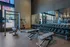 Modern and spacious gym featuring state-of-the-art equipment, ample free weights, and floor-to-ceiling windows with abundant natural light.