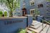 Inviting entrance of Library Park apartments featuring a modern facade, lush greenery, and sleek architectural details.