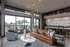 Chic apartment living room with modern decor, leather sofa, stylish armchair, and vibrant natural light from large windows overlooking a scenic balcony.