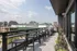 Chic apartment balcony boasting panoramic city views, sleek outdoor seating, and modern BBQ grills.
