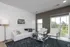 Bright and modern living room with elegant furniture, large windows, and stylish decor in a serene apartment setting.
