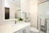 Modern bathroom featuring an elegant vanity with a sleek sink, polished mirror, and stylish towel accessories.