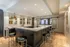 Luxurious and modern kitchen with sleek bar seating, elegant pendant lighting, and sophisticated cabinetry, perfect for entertaining.