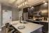 Modern kitchen featuring sleek dark cabinets, stainless steel appliances, and a stylish island with elegant pendant lighting.