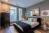 Chic bedroom with modern black furniture, elegant decor, and large windows offering ample natural light.