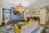 Luxurious living space featuring a stunning chandelier, elegant leather chairs, and a cozy seating area with vibrant decor.