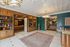 Elegant apartment lobby featuring classic wood paneling, a cozy seating area, and a chic chandelier, with tasteful decor and a vibrant patterned rug.