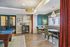 Elegant and inviting entertainment room with a luxurious pool table, chic dining nook with tufted seating, and sparkling chandeliers, perfect for social gatherings.