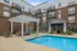 Inviting apartment complex with modern poolside amenities, stylish pergola, and cozy lounge area for relaxation.