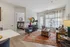 Chic and inviting living space featuring a cozy seating area with plush chairs, a vibrant area rug, and elegant decor. The natural light highlights the modern design, and the open doorway leads to a stylishly furnished bedroom.