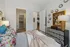 Charming bedroom with vibrant floral pillows, modern art, and cozy lighting leading to a spacious walk-in closet and elegant living area.