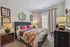 Elegant bedroom featuring a plush bed with vibrant cushions, stylish decor, and soft lighting for a cozy atmosphere.