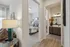 Inviting apartment interior showcasing a cozy bedroom with vibrant decor, adjacent to a stylish bathroom featuring modern fixtures and elegant wooden cabinetry.