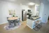 Modern kitchen and dining area with stylish stainless steel appliances, cozy round dining table, and elegant bar seating on sleek wood flooring.