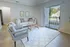 Bright and inviting living room with modern decor, spacious seating, and large glass doors opening to a scenic view.