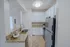 Modern kitchen with granite countertops, sleek stainless steel appliances, and elegant white cabinetry.