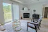 Bright living room with a scenic balcony view, featuring a cozy fireplace, elegant decor, and modern furniture.