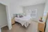 Cozy bedroom with soft carpeting, modern bed, and large window for natural light.