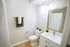 Elegant bathroom bathed in soft light, featuring a modern vanity with a sleek countertop, stylish mirror, and cozy accents like plush towels and greenery.