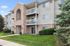 Charming apartment building with elegant brick facade, balconies, and lush landscaping for an inviting community feel.