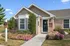 Charming brick exterior home with manicured garden and vibrant flowers at the entrance, ideal for future residents.