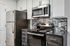Modern kitchen with sleek stainless steel appliances, chic tile backsplash, and elegant cabinetry for a stylish, functional space.