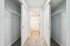 Spacious dual closet with sliding doors leading to a bright, contemporary bathroom, offering ample storage and modern elegance.