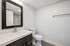 Modern bathroom with sleek vanity and large framed mirror, featuring elegant fixtures and a spacious shower.