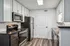 Modern kitchen with sleek dark countertops, stainless steel appliances, and elegant white cabinetry, offering a stylish and functional cooking space.
