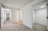 Inviting hallway with elegant wooden flooring and cozy carpeted rooms, leading to a spacious walk-in closet.