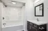Elegant bathroom with modern bathtub, stylish vanity with mirror, and polished fixtures.