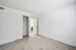 Bright, minimalistic bedroom with plush carpet and sliding closet door, leading to a modern bathroom with sleek finishes.