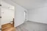 Bright and inviting bedroom with plush carpeting and en-suite bathroom featuring elegant wooden flooring.