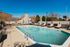 Inviting outdoor pool area with sun loungers and lush greenery, perfect for relaxation and enjoyment.
